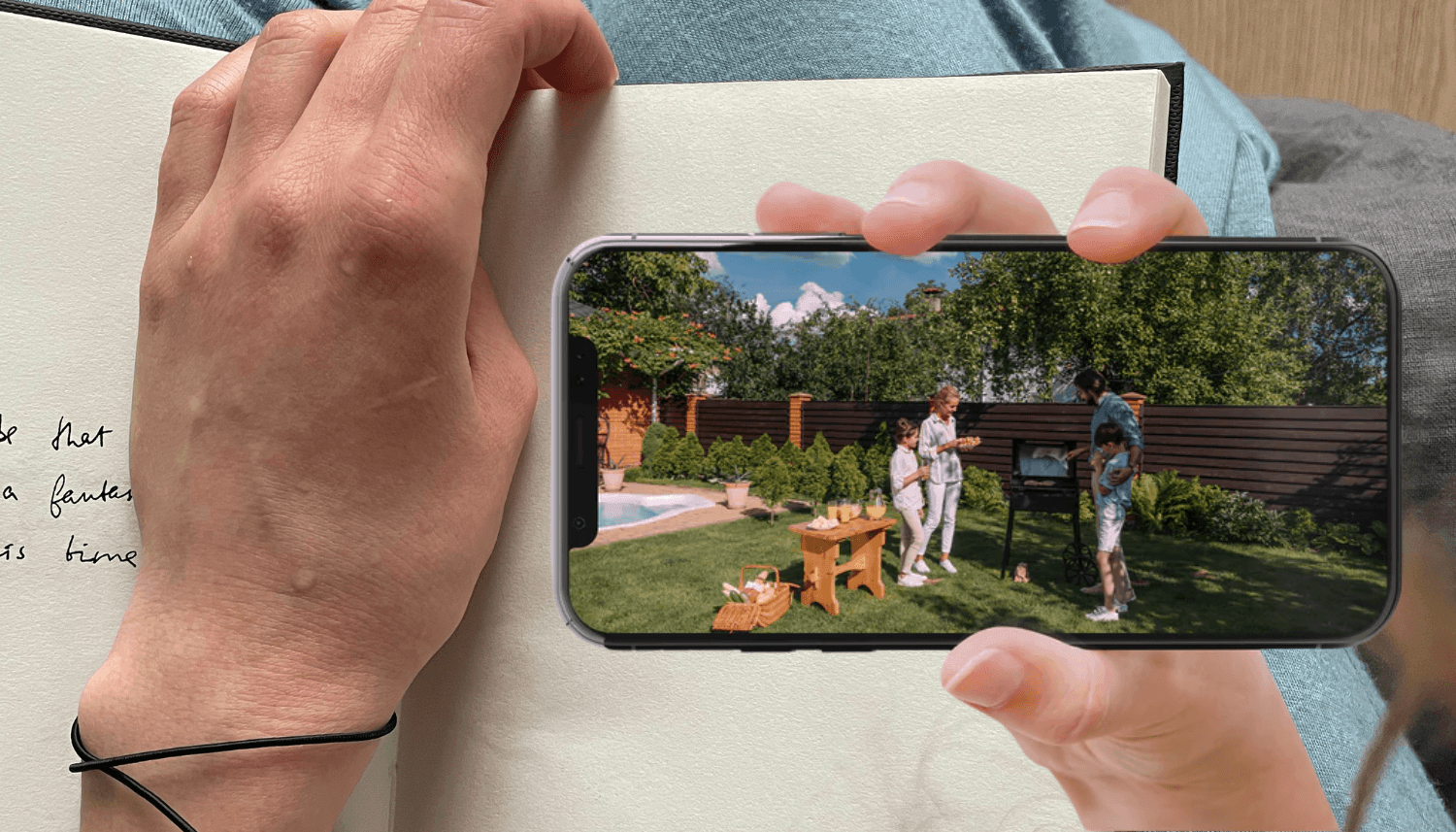 5 Reasons Smart Security Cameras Make the Perfect Gift for Mom | woman paused writing on notebook to look at the feed of Toucan Wireless Security Camera S4 on smart phone