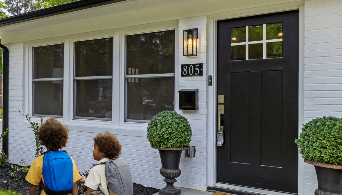 Children leaving a front entrance with a Toucan video doorbell beside the door