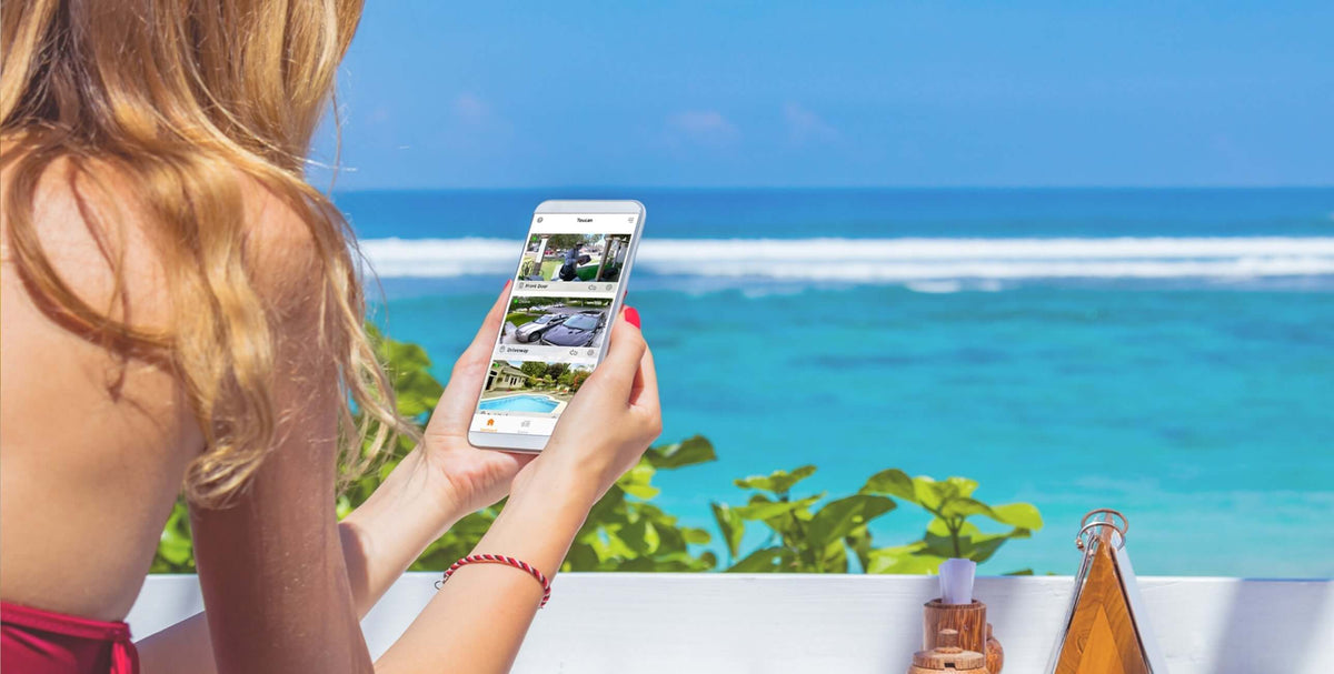 Person using a smartphone beside a pool in a summer home-security guide