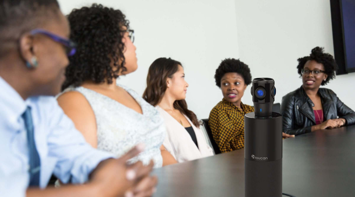 People in a meeting with a Toucan 360 conference camera on the table