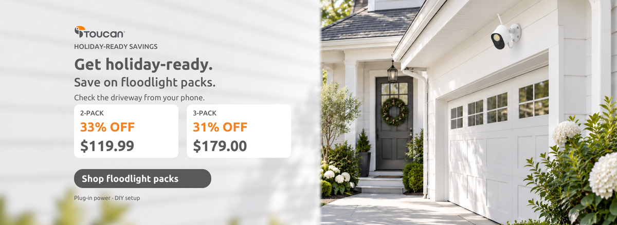 Toucan floodlight camera above a bright holiday driveway. Two-pack $119.99, 33% off; three-pack $179.00, 31% off. Shop floodlight packs.