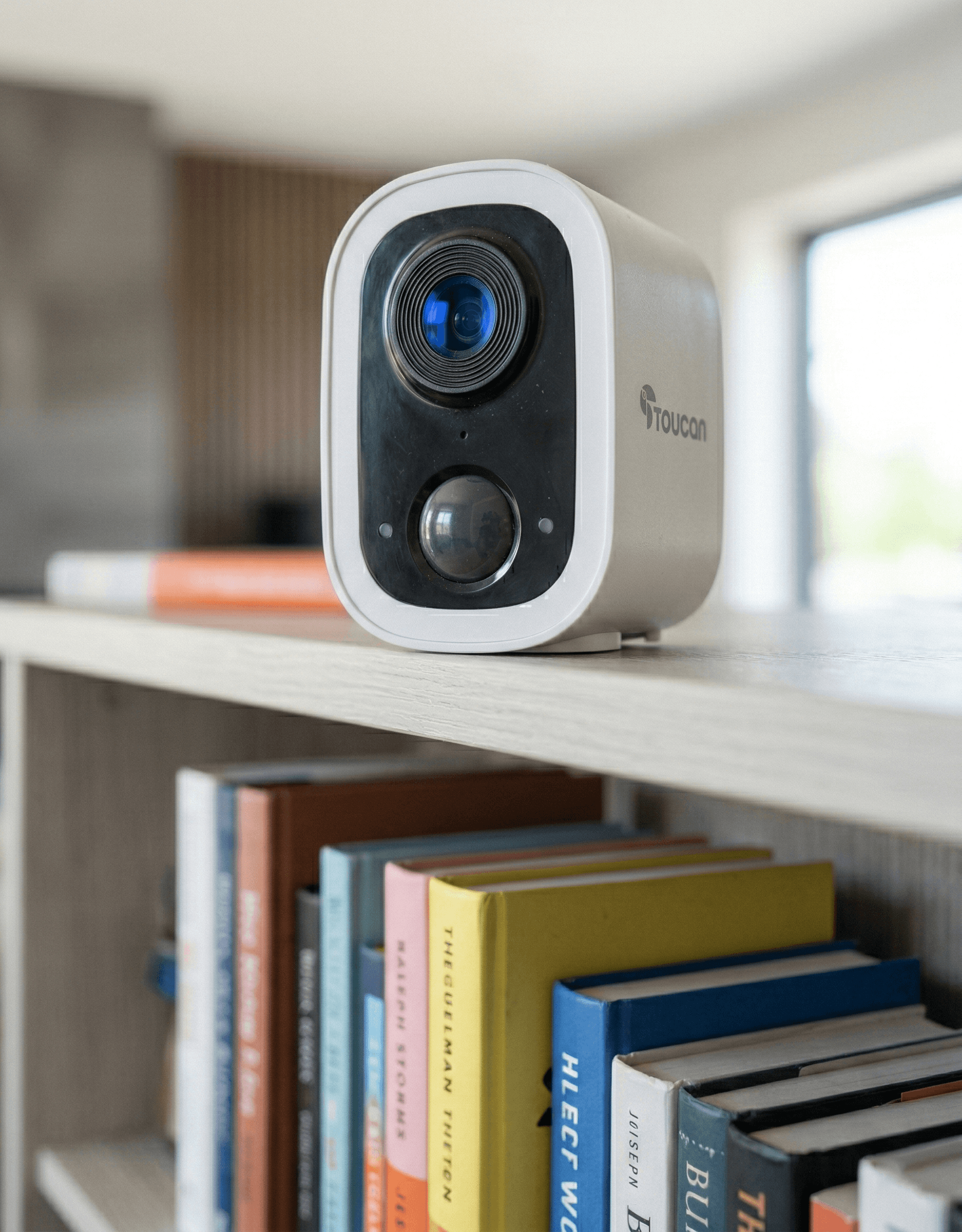 Security camera on a shelf with books in the background