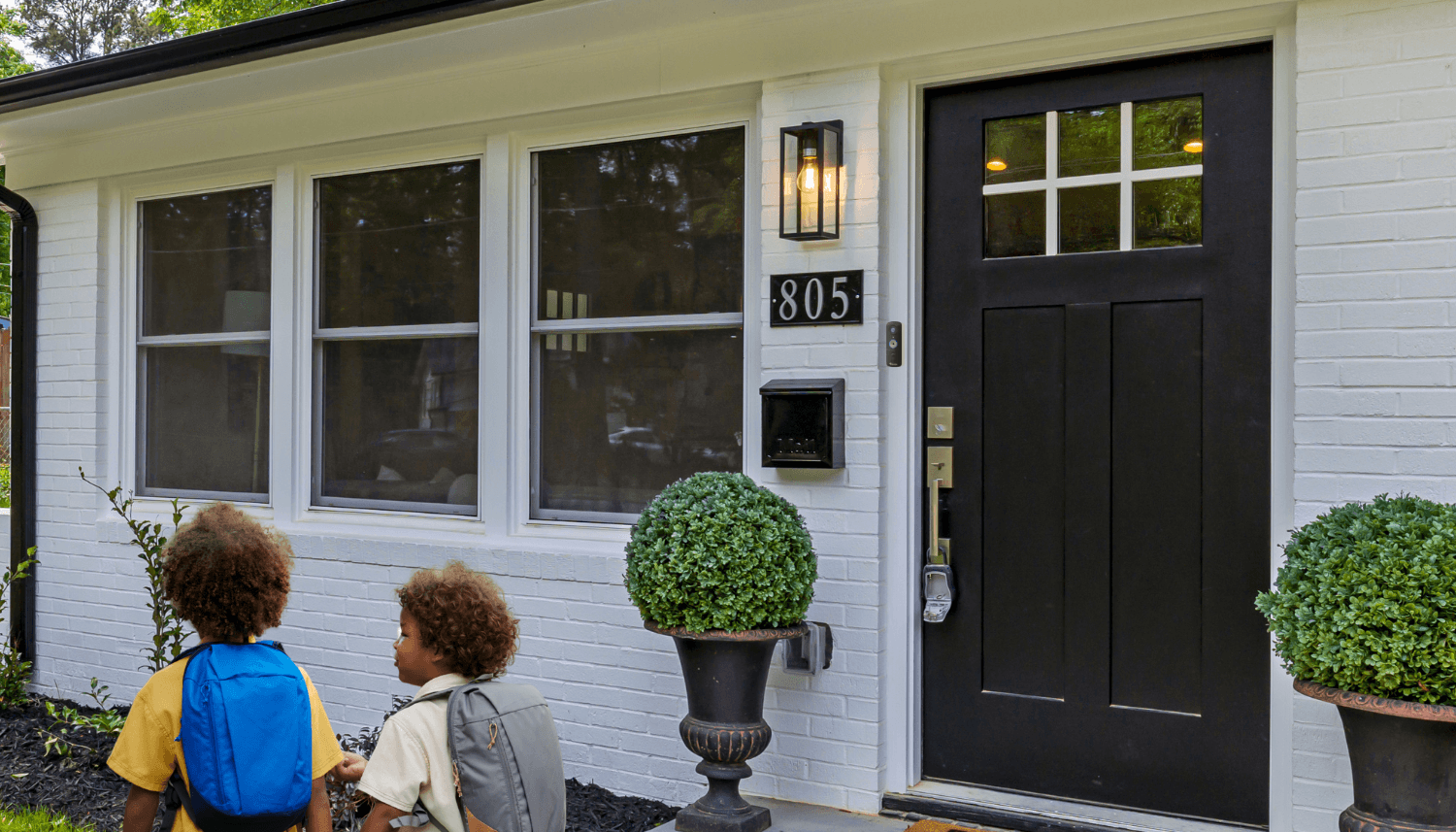 Back-to-School Safety Tips with a Wireless Video Doorbell | two young school kids walking away from their home's front door with a toucan wireless video doorbell camera v3 installed beside it