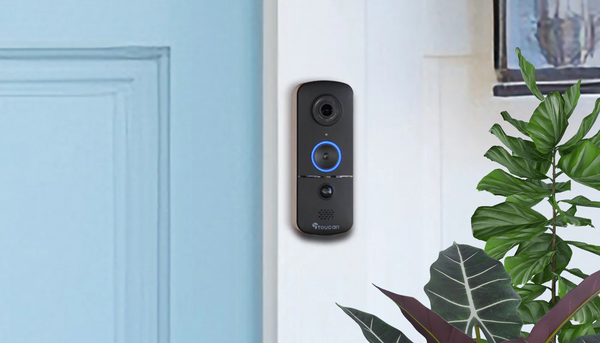Toucan Wireless Video Doorbell V3 Includes Wireless Doorbell Chime installed beside a baby blue front door with outdoor plants near it
