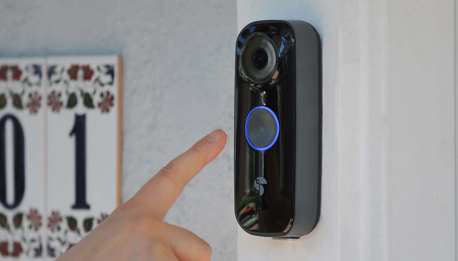 Smart Doorbell Cameras: Keeping Homes Safe on St. Patrick’s Day | person's finger about to ring the Toucan Wireless Video Doorbell PRO