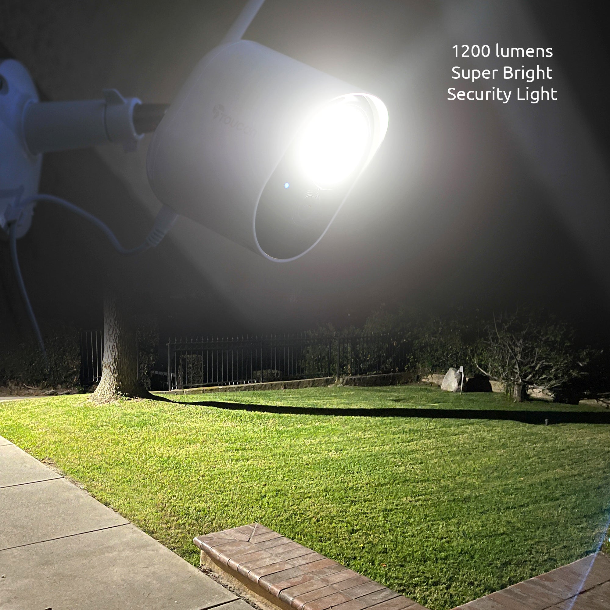 Toucan Security Floodlight Camera with 1200 lumens super bright security light illuminating a yard at night.